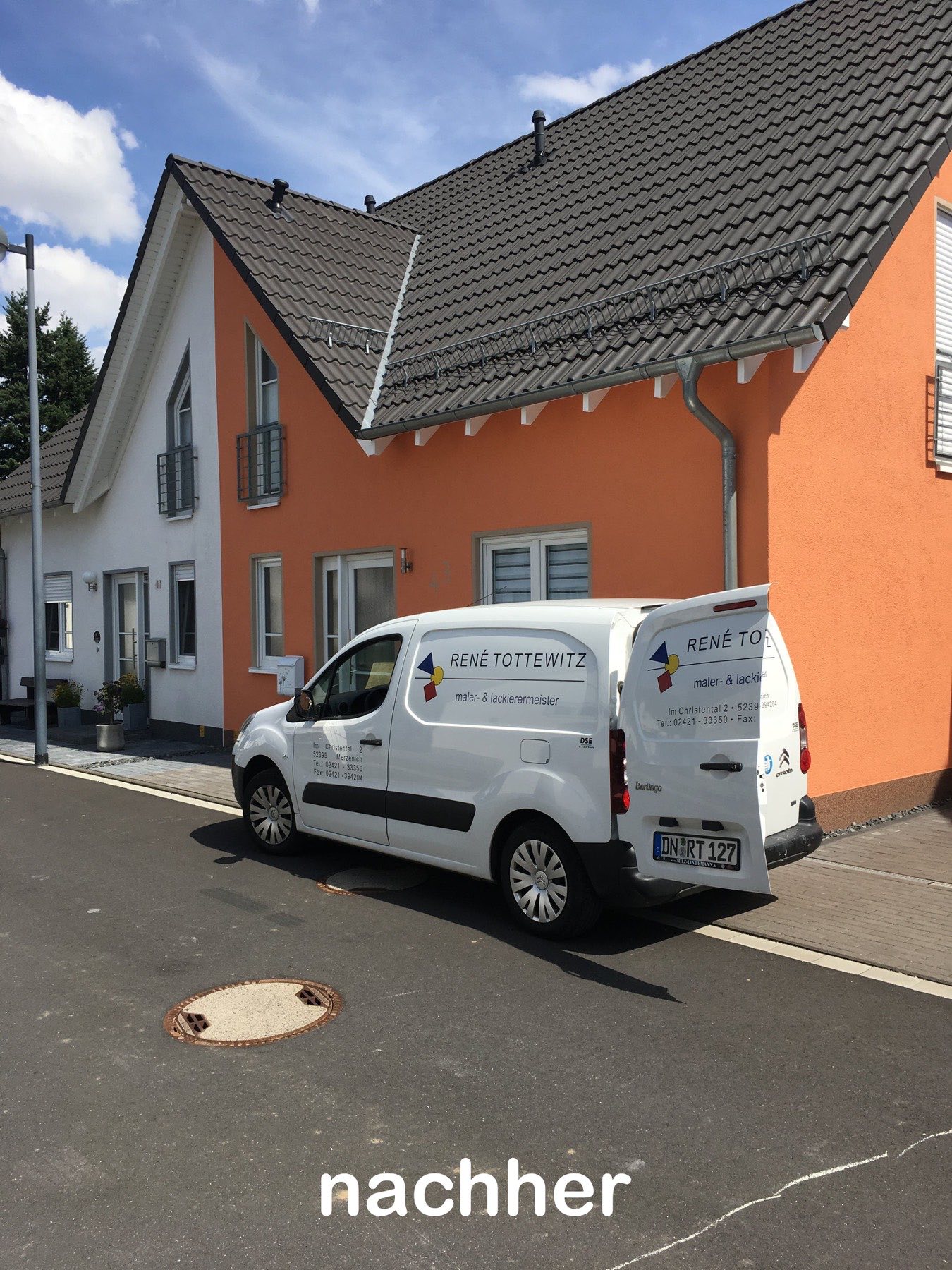 Frisch gestrichene orangefarbene Fassade mit Firmenfahrzeug in Merzenich